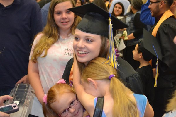 Lemoore Middle College High School grad Mikayla Smith with family moments after the conclusion of Friday's graduation ceremony.